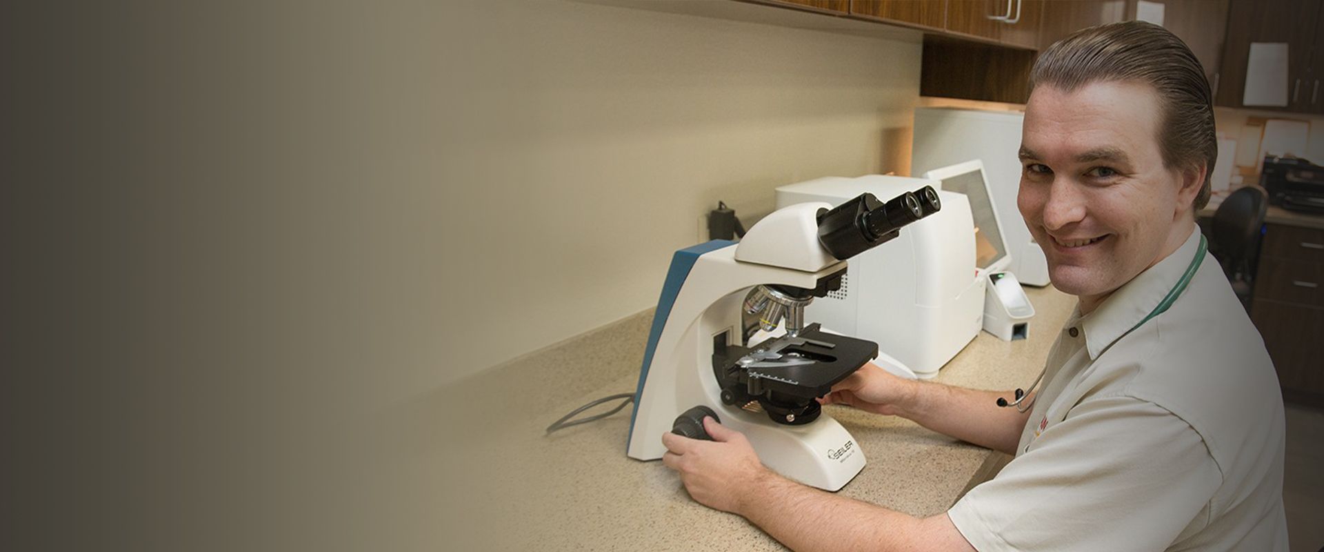 doctor benjamin savard using a microscope to check diagnostic tests at raintree pet medical center